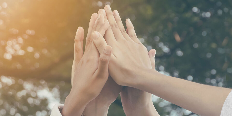 Mains de personnes diverses se rencontrent joyeusement; symbolise communauté et cohésion
