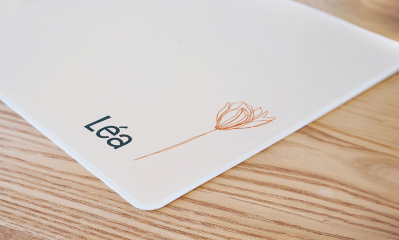 Set de table personnalisé avec un prénom et une fleur posé sur une table