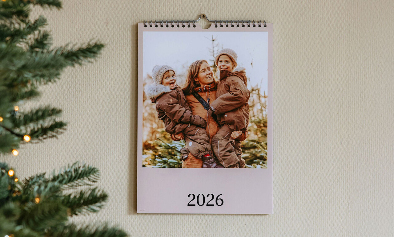 Un calendrier mural montre une scène familiale affectueuse avec des enfants à l'extérieur.