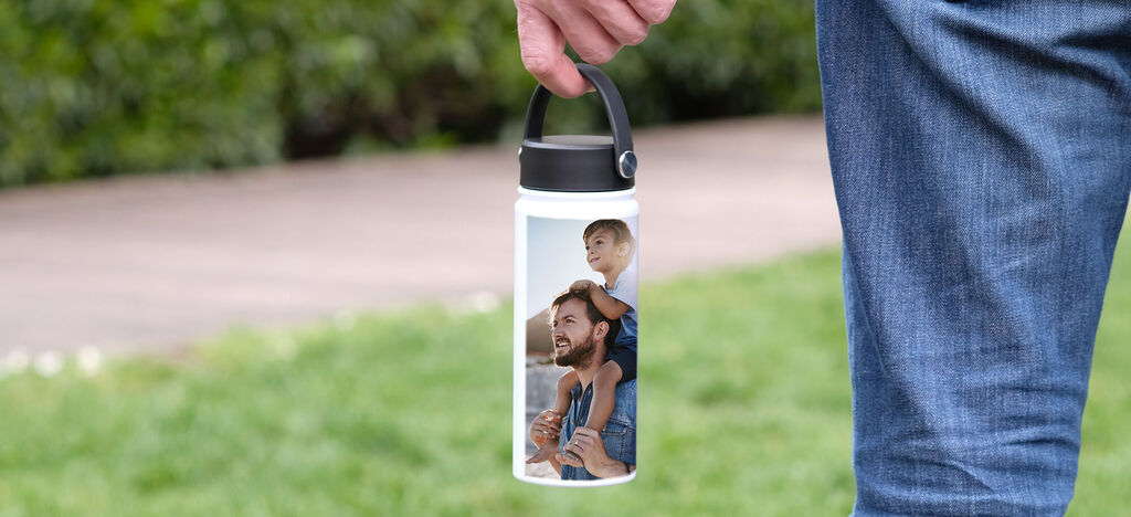 Une personne tenant une bouteille personnalisée avec la photo d'un enfant et d'un père.
