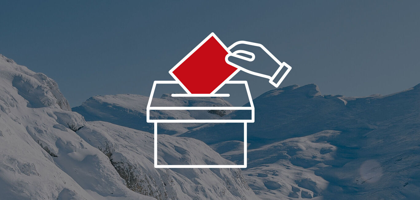 Une main jette un bulletin rouge dans une urne devant un paysage de montagne enneigé