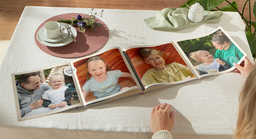 Livre Photo CEWE avec double page panoramique montrant 4 photos de famille