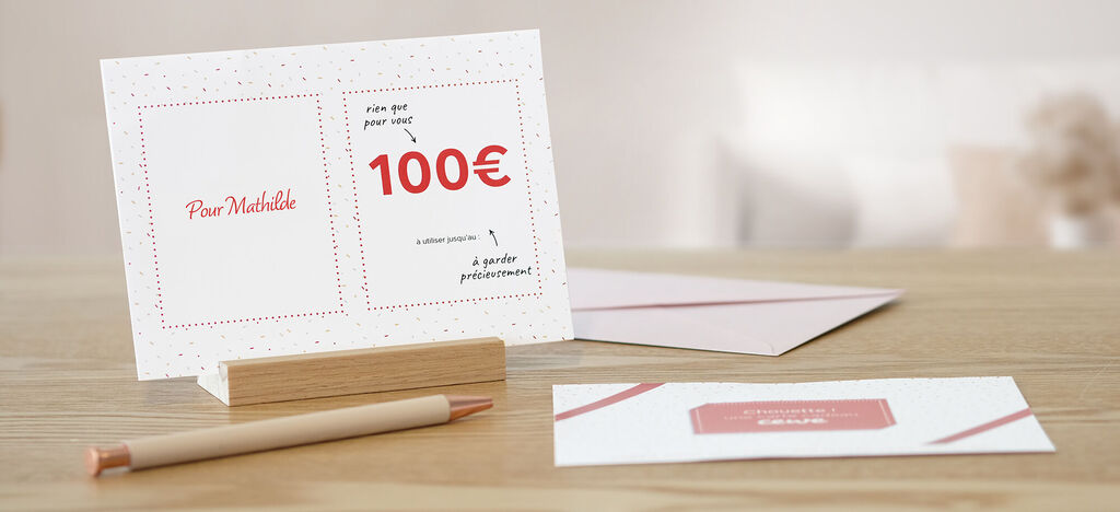 Cartes de vœux CEWE avec un bon de 100 euros sur une chaise en bois dans une pièce lumineuse