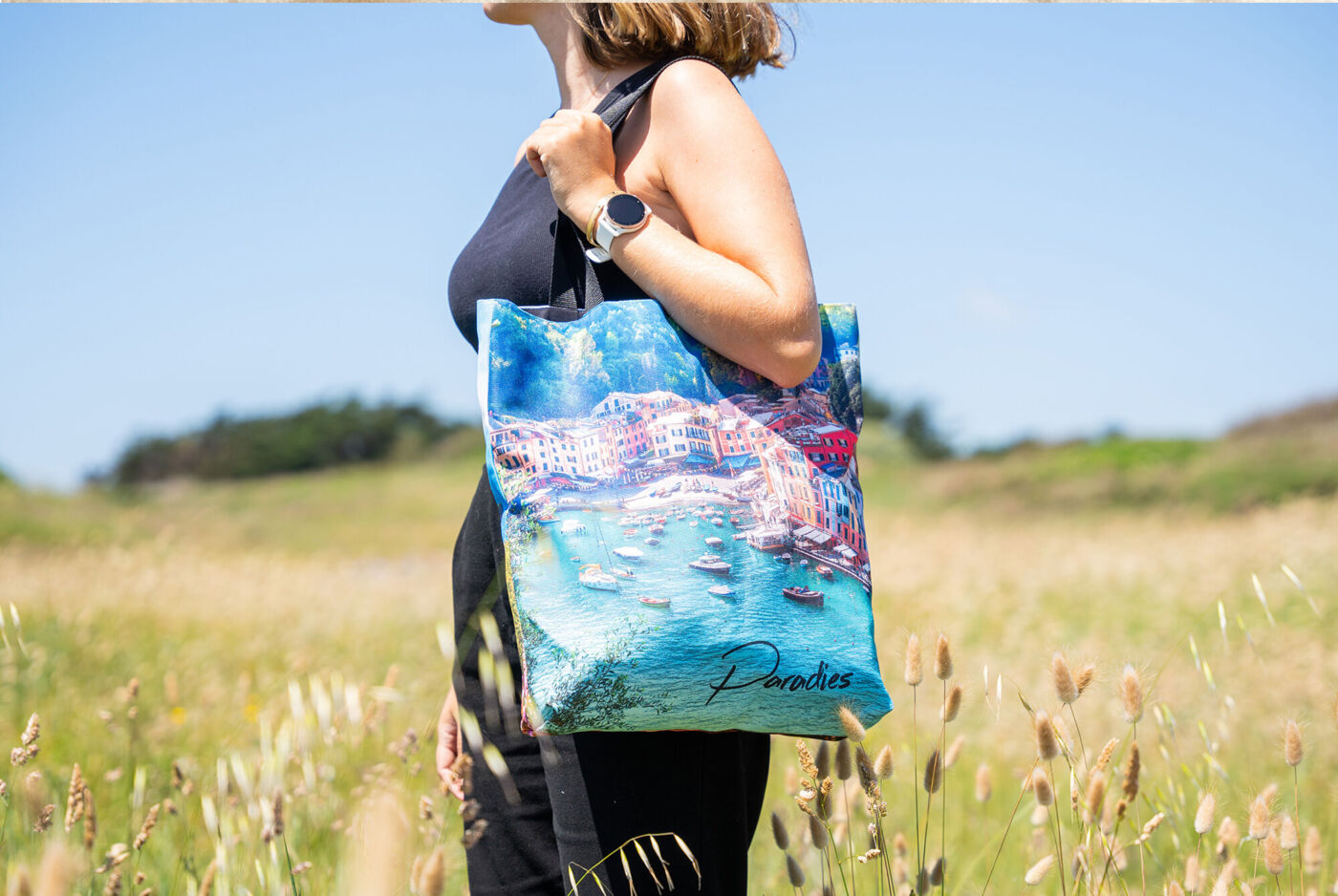Femme avec un sac en tissu coloré dans un champ.