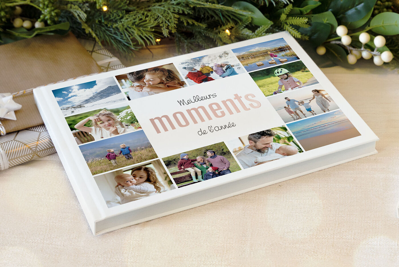 Un album photo intitulé "Meilleurs moments de l'année" avec plein de photos de famille, posé au pied du sapin de Noël