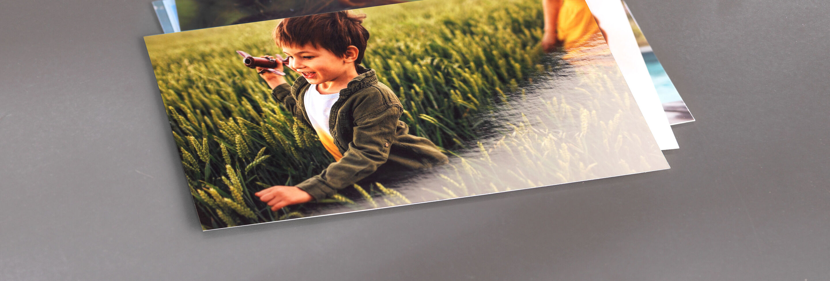 Un enfant court joyeusement à travers un champ vert avec un appareil photo. Il profite du moment et le capture.