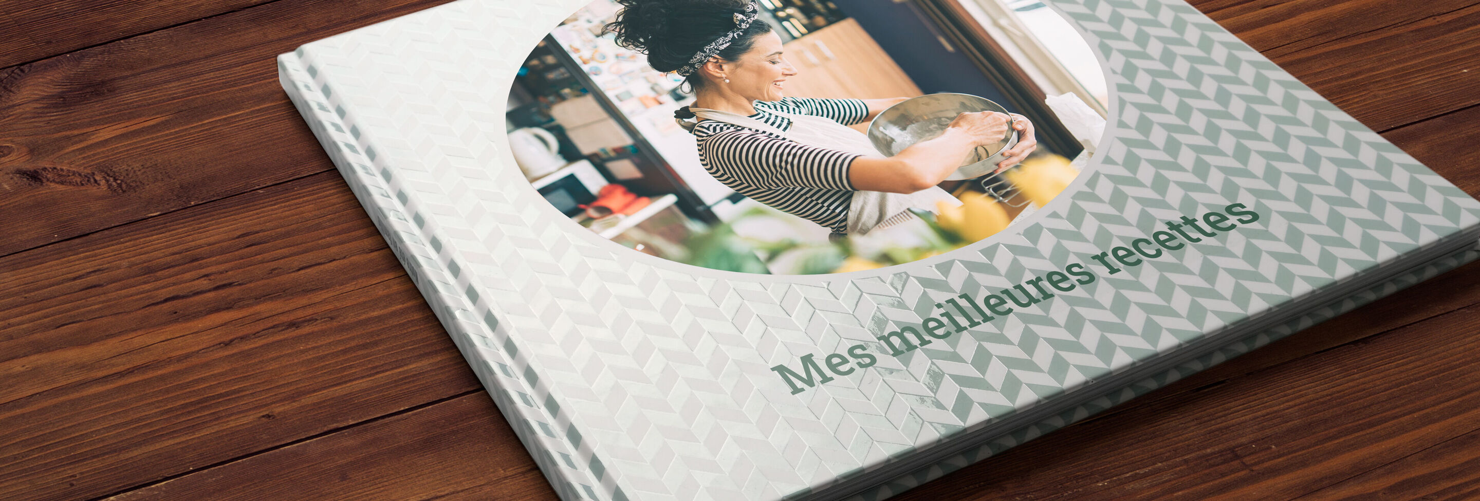 Un CEWE PHOTOBOOK sur une table en bois avec un design moderne et des images fraîches.