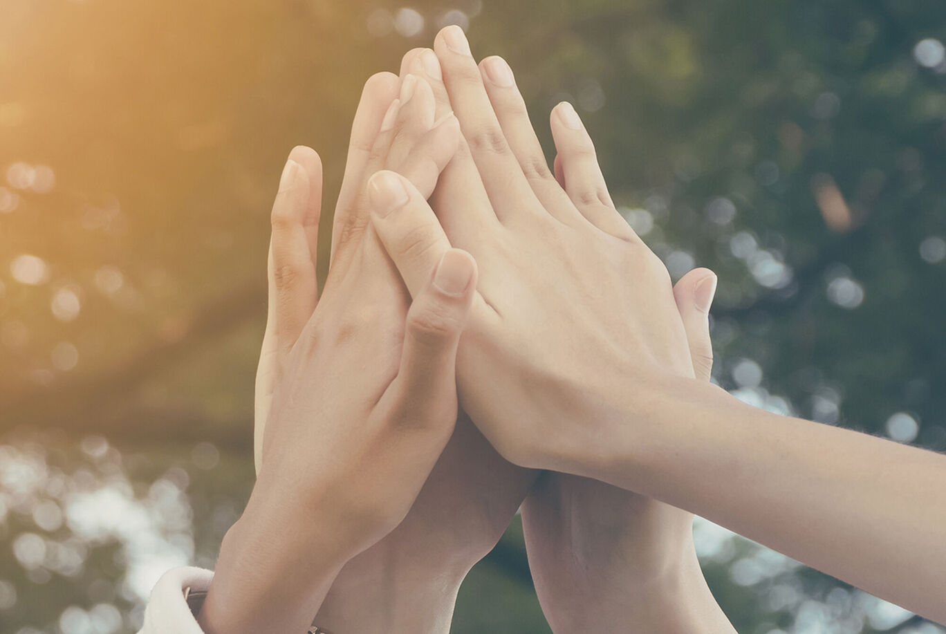 Des mains de différentes personnes, posées les unes sur les autres.