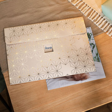 Élégant CEWE Photoalbum avec des motifs dorés sur une table