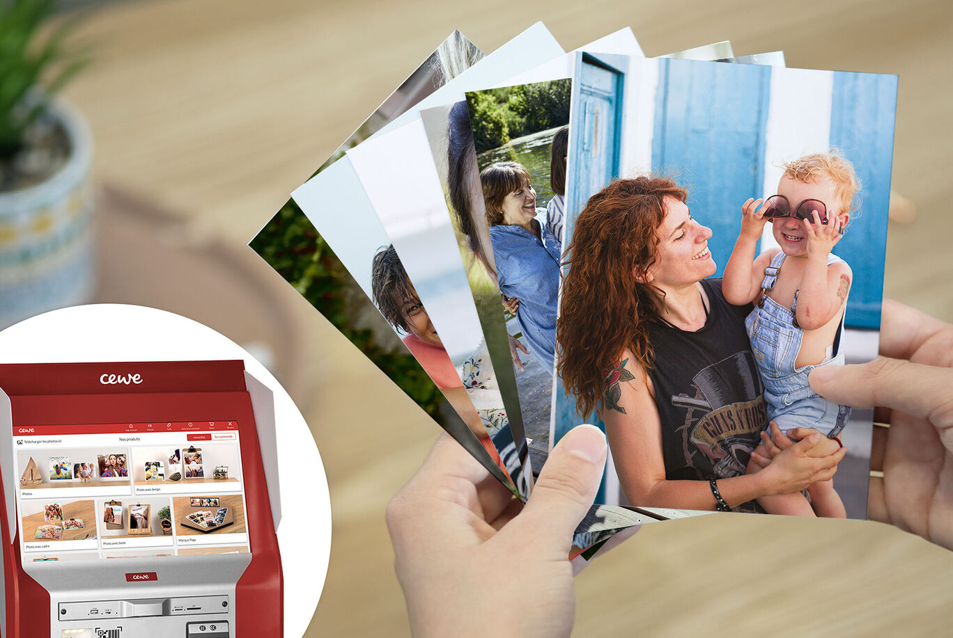 Une personne tient une sélection de photos CEWE, une imprimante photo en arrière-plan.