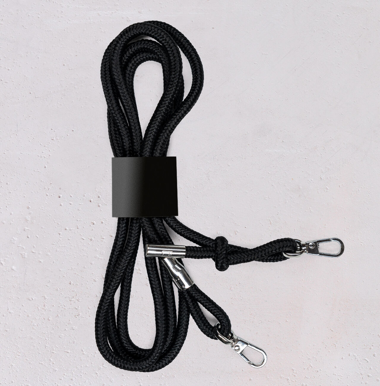 Paire de lacets noirs avec fermetures à crochets, soigneusement regroupés.