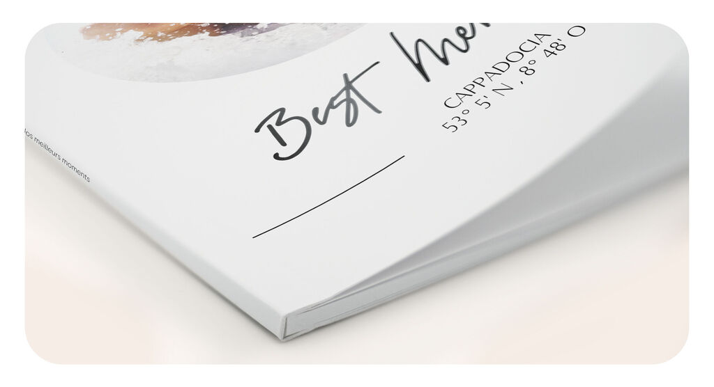 Gros plan d'un ALBUM PHOTO CEWE avec une couverture élégante et une tranche légèrement ouverte