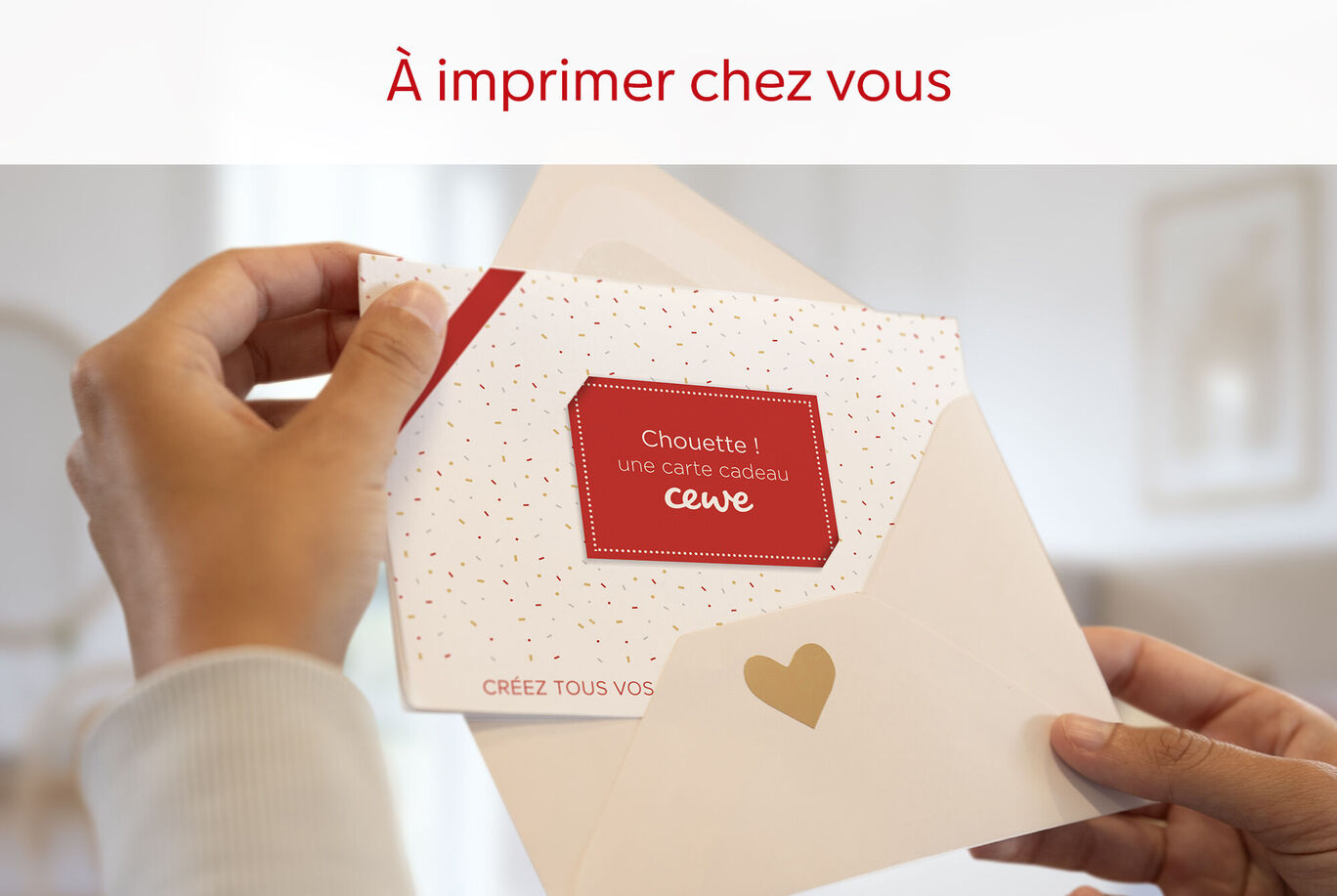 Une personne tient une carte de vœux CEWE dans une main, ouverte avec une enveloppe blanche