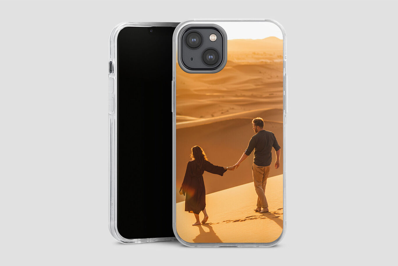 Un couple marche main dans la main sur des dunes de sable doux.