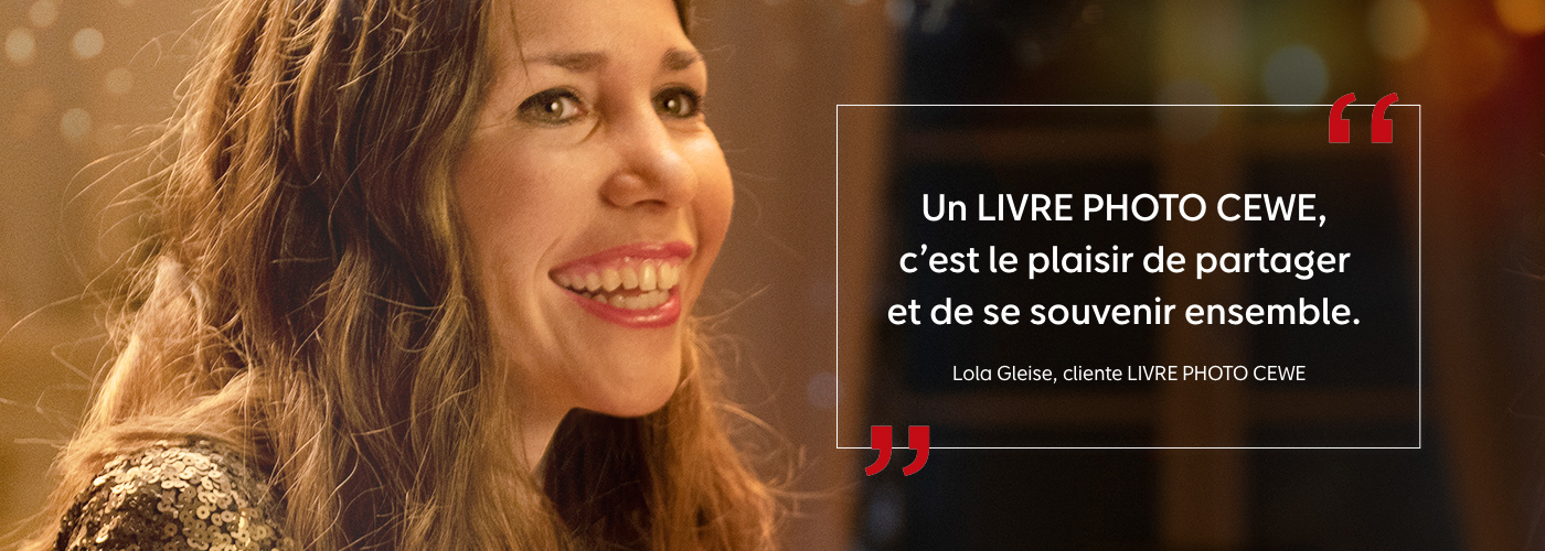 Une femme regarde un LIVRE PHOTO CEWE plein de souvenirs.