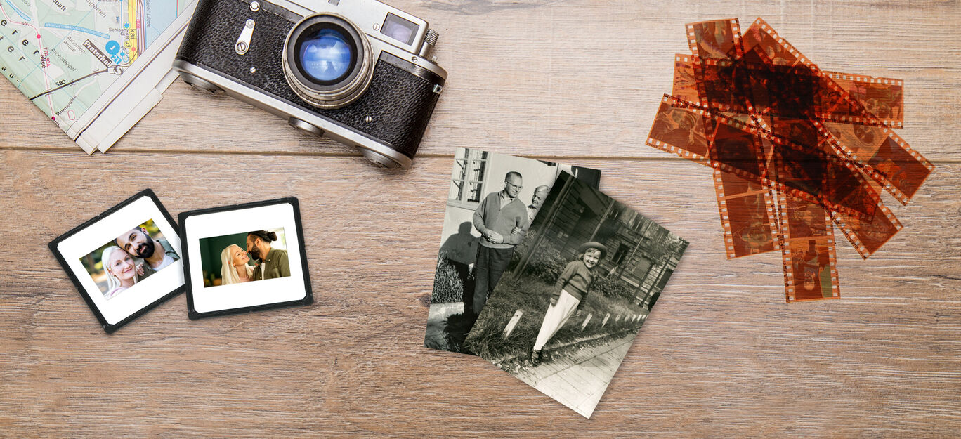 Un appareil photo analogique, des photos anciennes et des négatifs sur une table en bois, ravivent des souvenirs de voyages passés