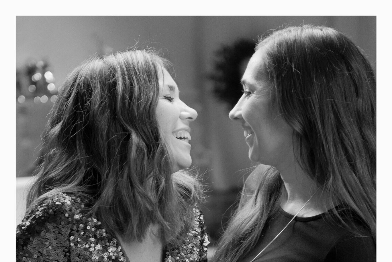 Deux femmes en tenues glamoureuses discutent joyeusement.