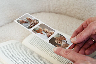 Une personne tient un album photo CEWE avec des photos de sa famille et d'un bébé en lisant.