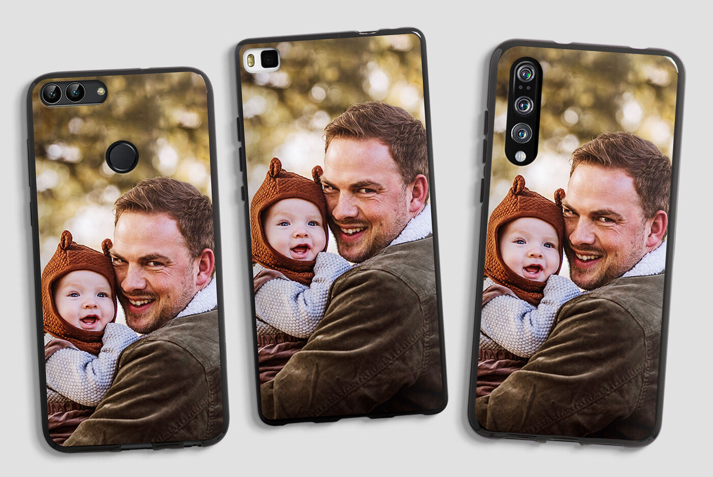 Un homme tenant un enfant dans ses bras, tous deux souriant et profitant d'un moment à l'extérieur