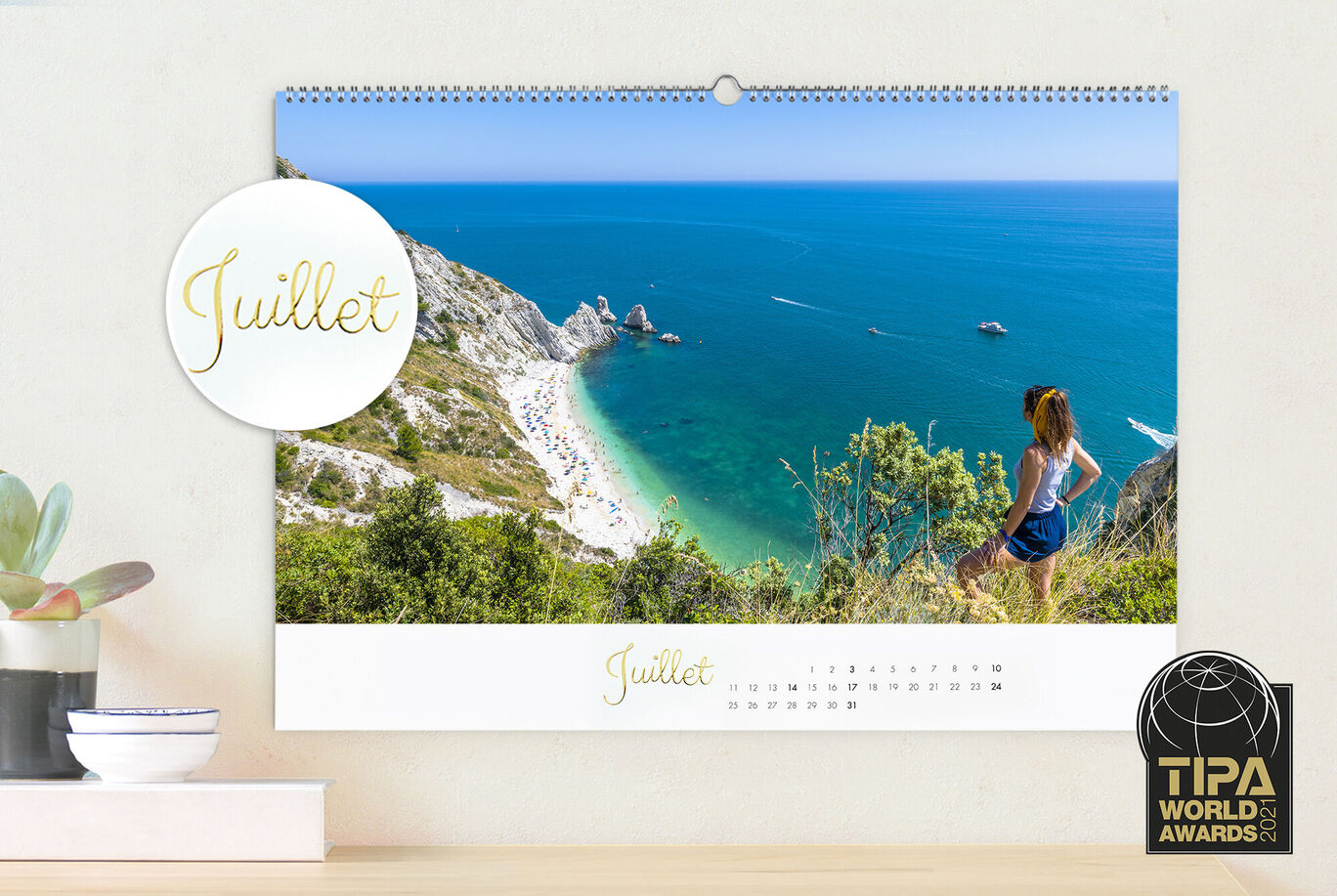 Feuille de calendrier de juillet avec scène de plage et personne regardant la mer.