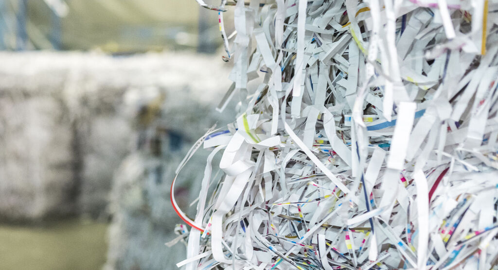 Gros plan sur du papier coloré découpé en bandes et utilisé dans un processus de recyclage.