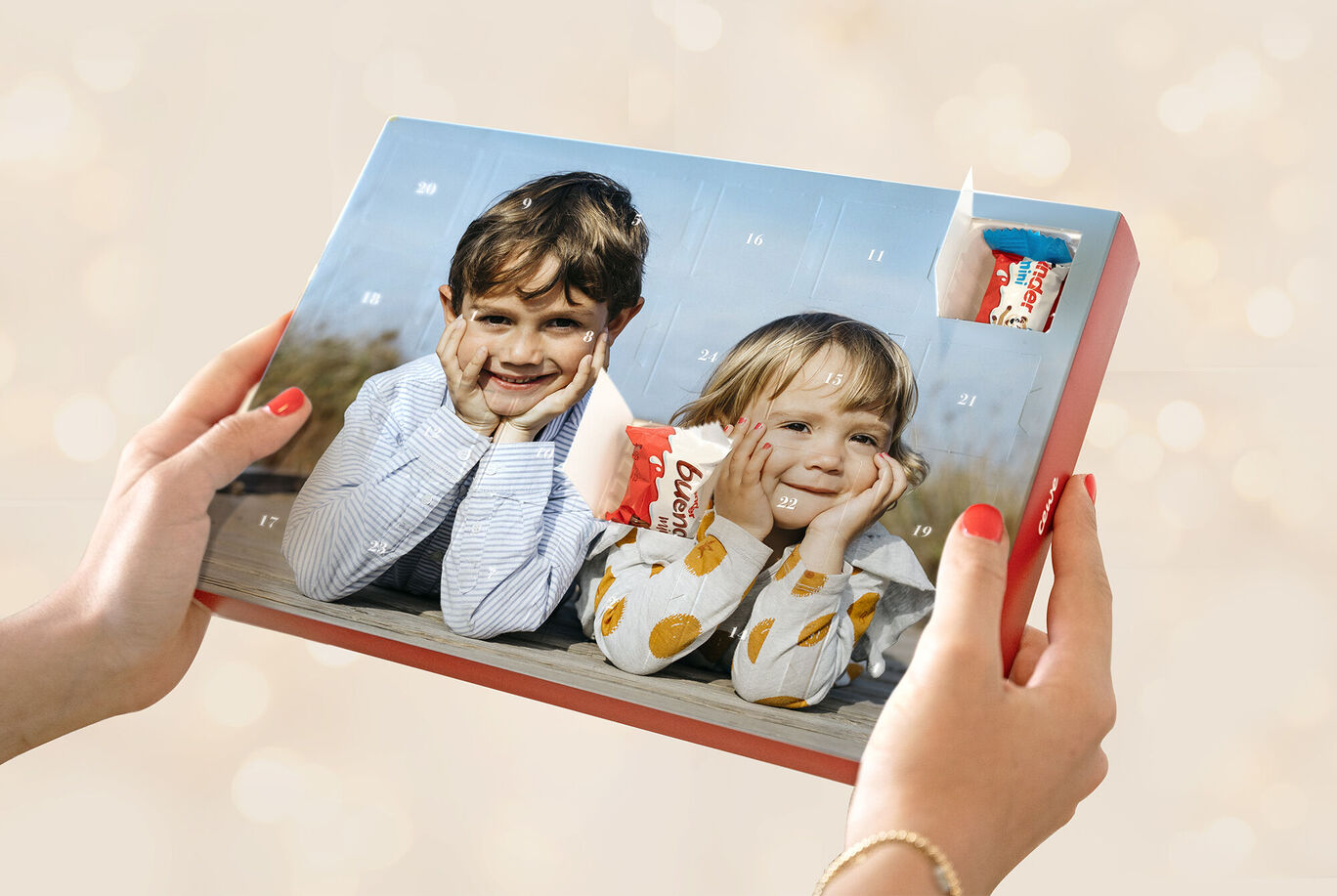 Un calendrier de l'Avent joliment conçu dans les mains de deux enfants regardant avec excitation