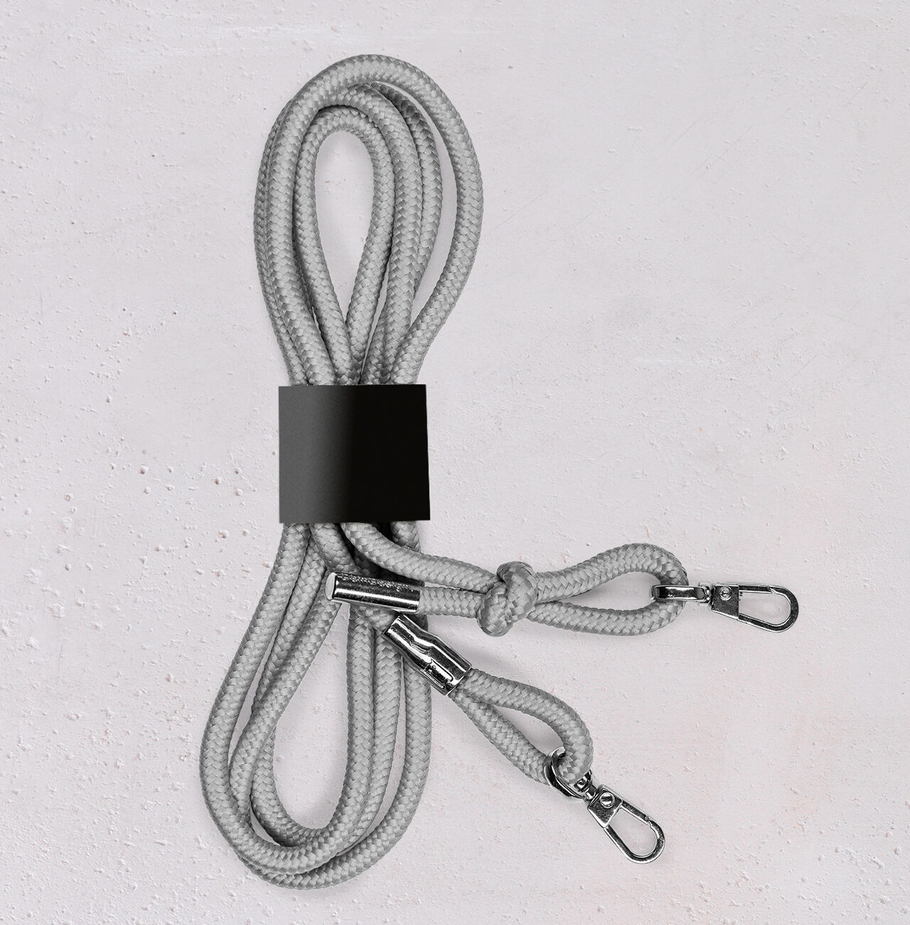Corde grise avec deux mousquetons, soigneusement enroulée.