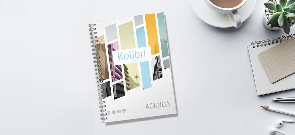 Agenda colorée avec le titre "Colibri" sur une table