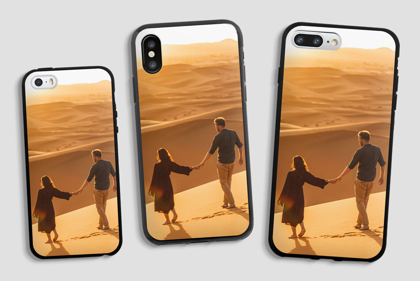 Deux personnes se tenant par la main sur une dune au coucher du soleil, entourées d'un désert doré