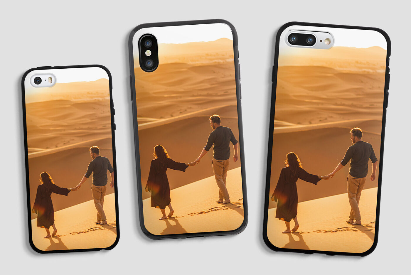 Deux personnes se tenant par la main sur une dune au coucher du soleil, entourées d'un désert doré