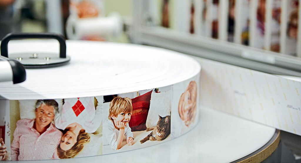 Dos de livres photo CEWE empilés avec des images de famille et d'amis