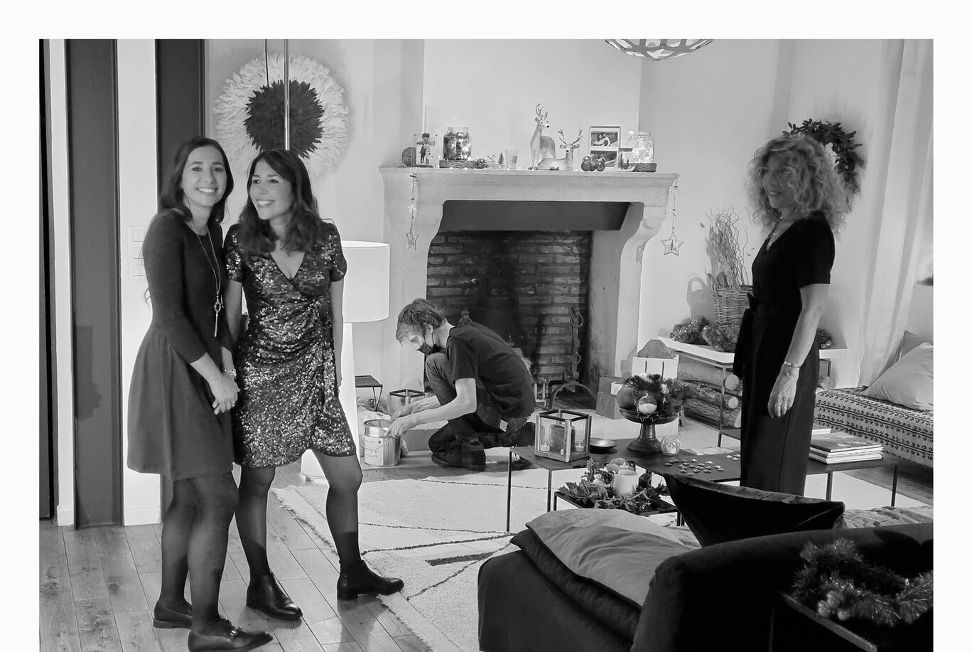 Deux personnes en vêtements élégants discutent dans une pièce élégante, tandis qu'une personne crée avec des couleurs et des matériaux.