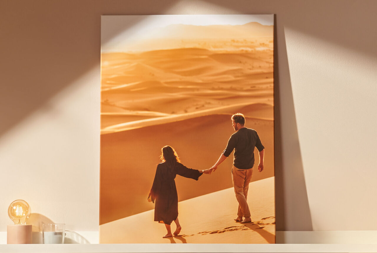 Un couple explore le désert au coucher du soleil, main dans la main.