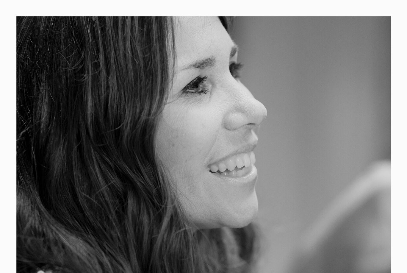 Une femme aux longs cheveux sourit et parle.