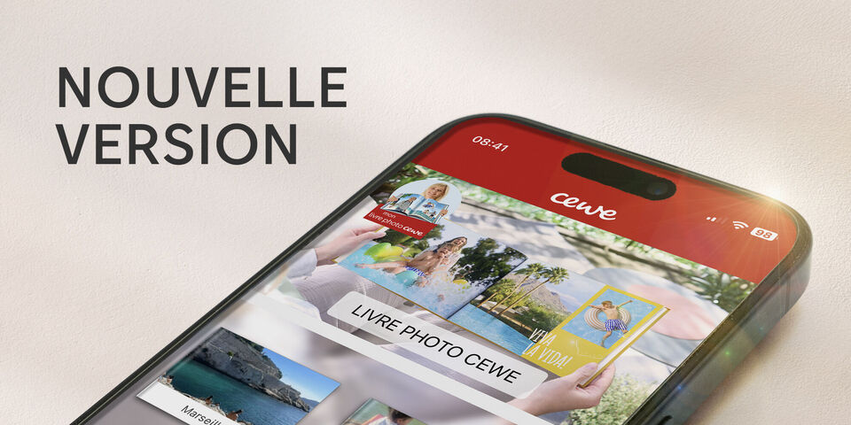 Le smartphone montre la nouvelle version de l'application CEWE avec des photos.