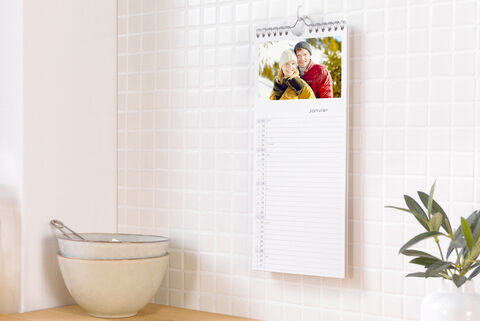 Un calendrier mural avec une photo d'un couple heureux en hiver, entouré d'une ambiance chaleureuse