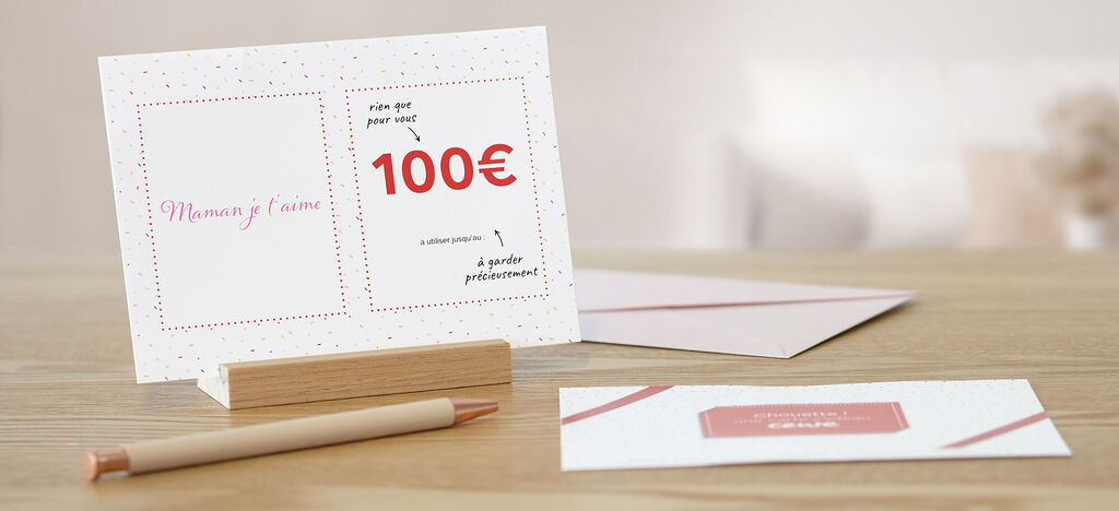Deux cartes de vœux CEWE soigneusement décorées sur une table en bois avec un stylo.