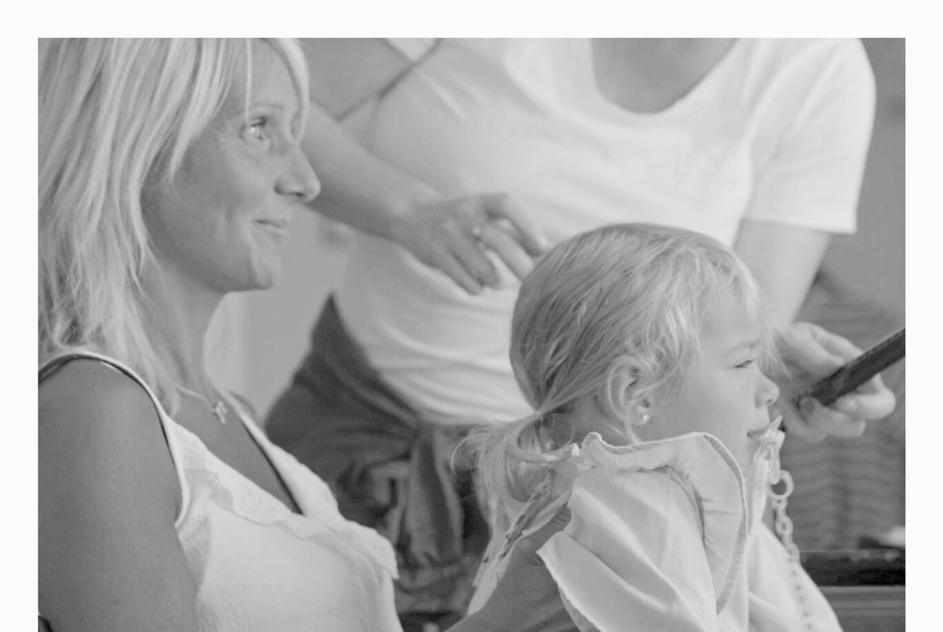 Un beau moment où une femme coiffe un enfant. C'est une scène tendre et intime.