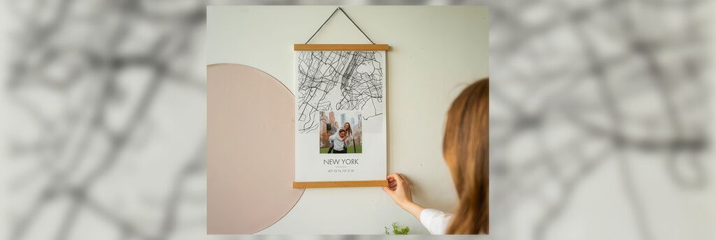 Une personne montre fièrement un poster avec un plan de New York. Un souvenir joyeux.