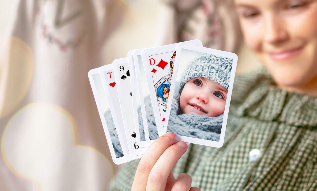 Jeune fille tenant un jeu de cartes personnalisé dans sa main