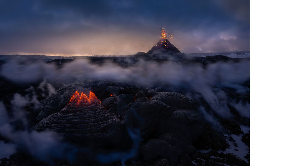 Deux volcans actifs au crépuscule, la fumée et la lave brillent. Un événement naturel impressionnant.