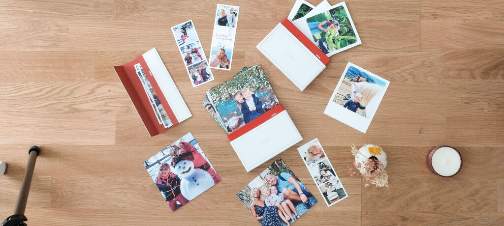 Une belle table avec des livres photo CEWE et des photos de moments de bonheur.