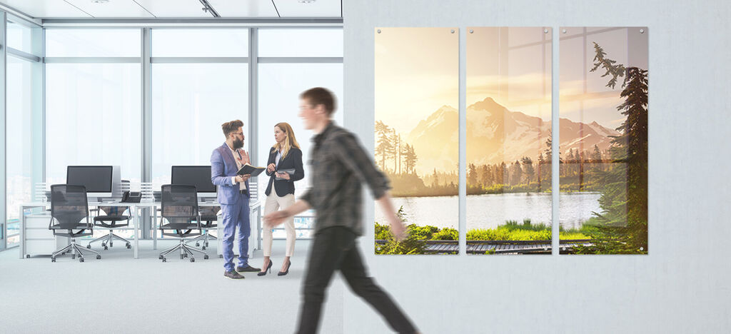 Une magnifique œuvre murale d'un paysage de montagnes et d'un lac dans un bureau moderne. Deux personnes discutent au premier plan.