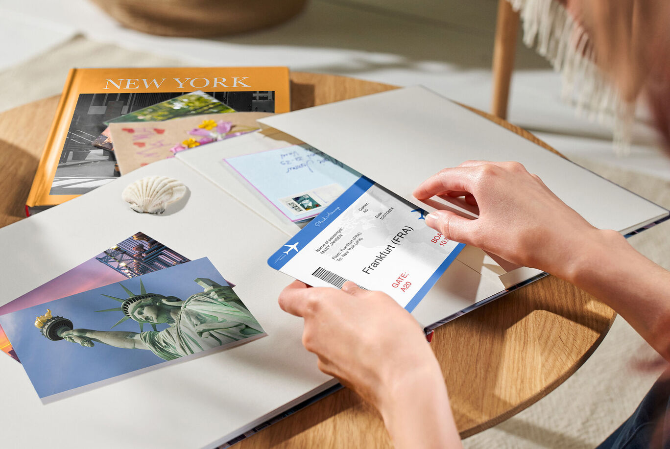 Une personne insère un billet d'avion dans la pochette souvenir du livre photo