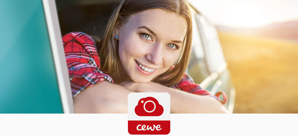 Une personne profite du coucher de soleil depuis une voiture, souriant heureusement avec les bras appuyés sur la fenêtre. CEWE.