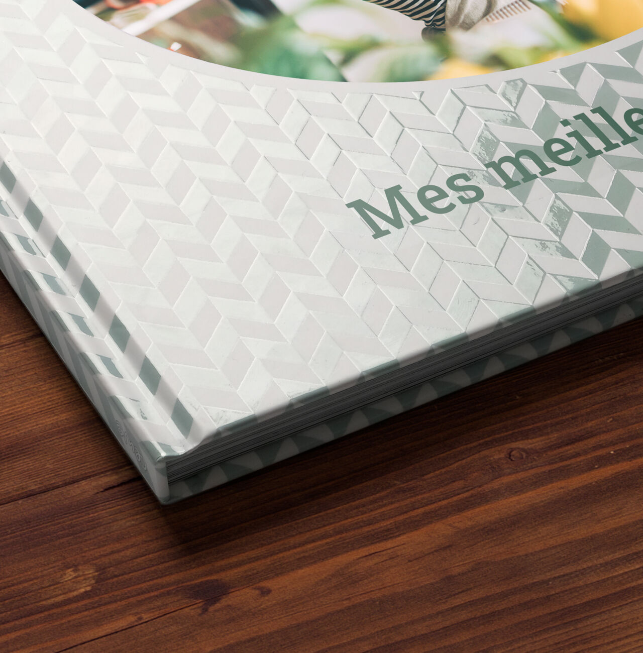 Gros plan d'une couverture CEWE PHOTOBOOK avec un design élégant et le texte 'Mes meilleures souvenirs'.