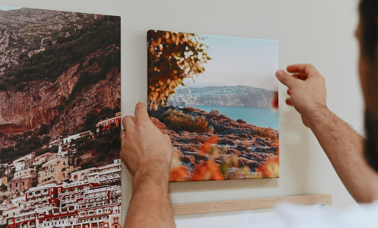 Photo de paysage sur toile en train d'être posée sur un mur