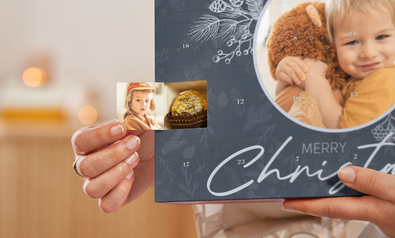 Une personne tient un livre photo CEWE avec des souvenirs affectueux.