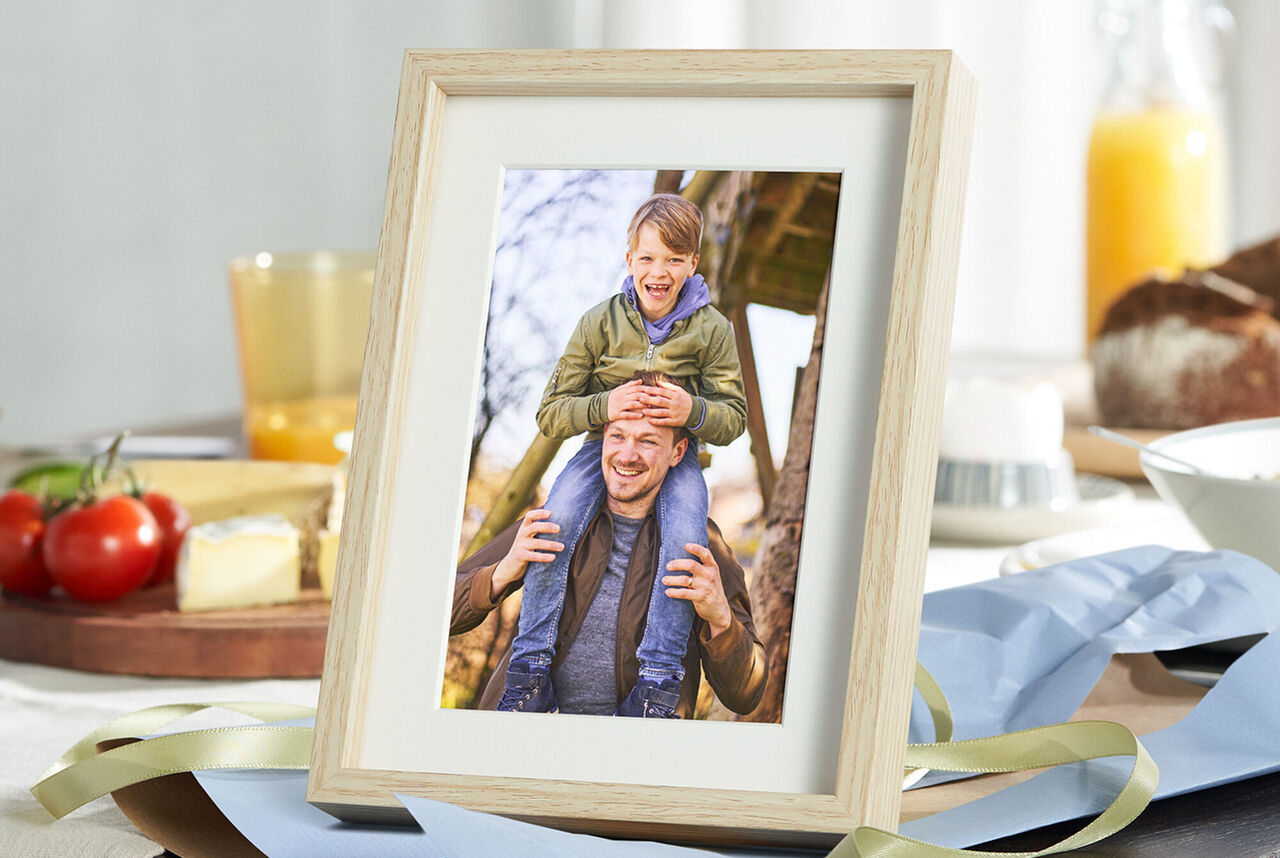 Un père avec son enfant sur les épaules dans un cadre.