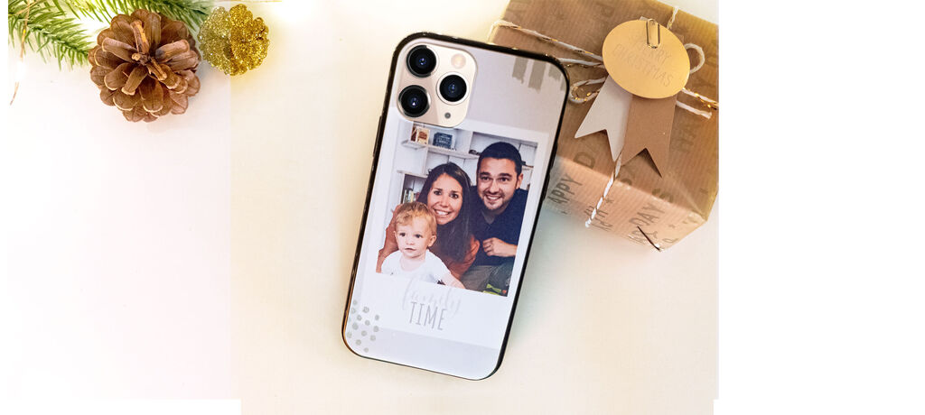 Un smartphone sur un joli cadeau. Il affiche une photo de moments heureux avec un enfant.